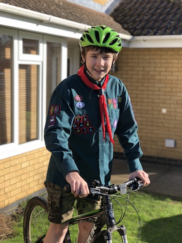 Matthew on his bike, in Scout uniform